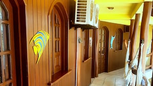 Un pasillo con paredes de madera, ventanas arqueadas y suelo de baldosas.