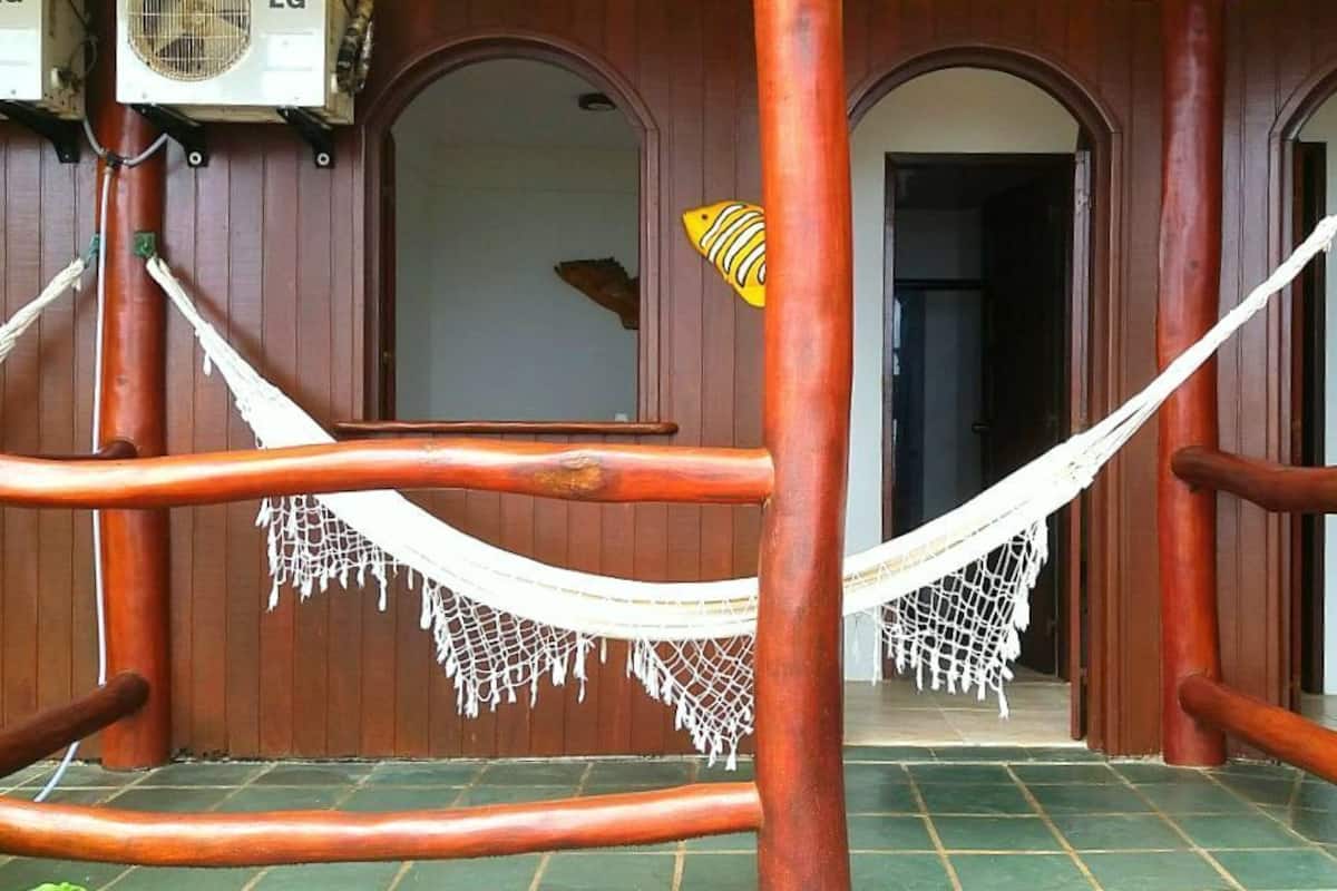 A wooden structure with a hammock and a fish decoration.