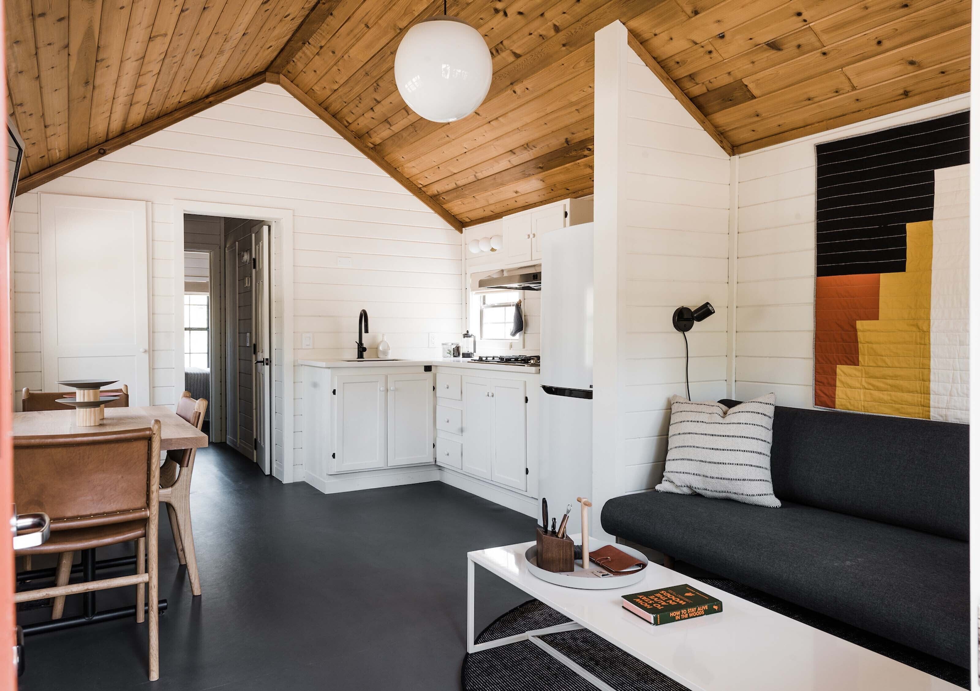 A compact living space with a dining area, kitchenette, and a sofa.