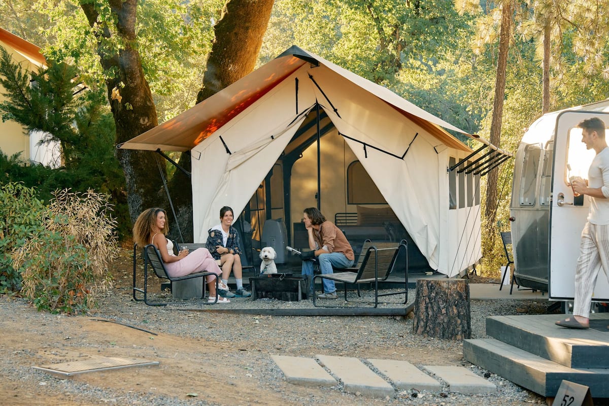 A campsite with a tent and a trailer.