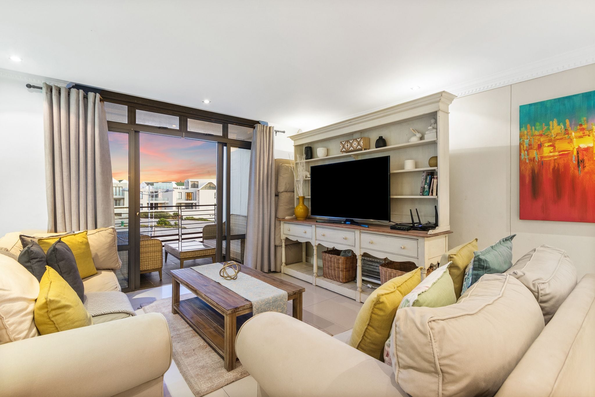 Una sala de estar moderna con un sofá, una mesa de centro, un televisor de pantalla plana y una chimenea.