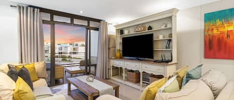 Una sala de estar moderna con un sofá, una mesa de centro, un televisor de pantalla plana y una chimenea.
