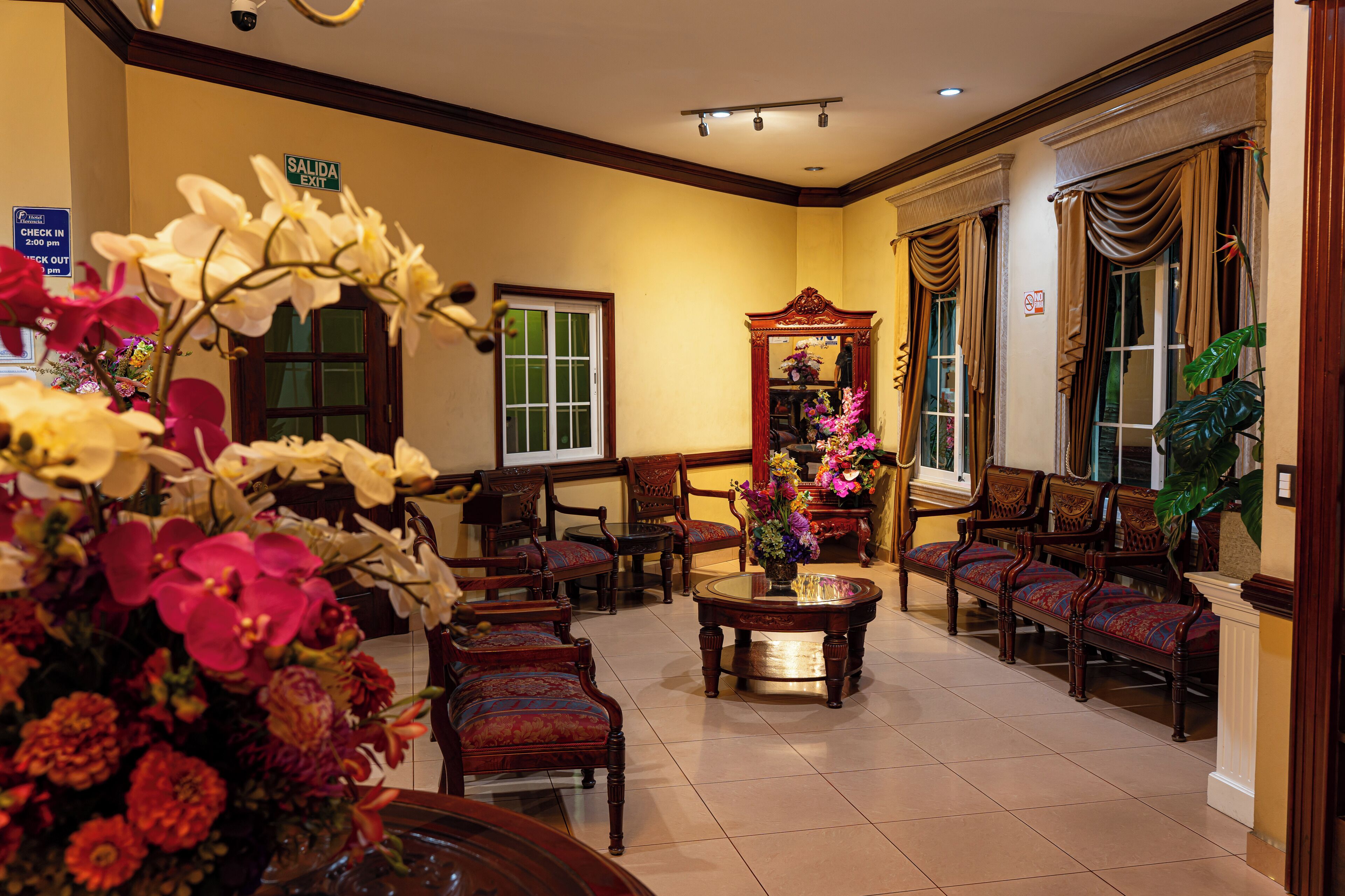 A hotel lobby with a check-in desk, seating area, and a mirror.