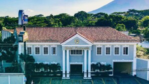A two-story building with a red-tiled roof, a central entrance with columns, and a sign reading "Hotel Firenze". - Hotel Florencia San Miguel (San Miguel)