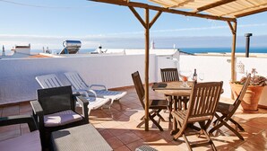 A terrace with a wooden pergola, white walls, and a view of the sea. - Apartment Kornelius (Carvoeiro)