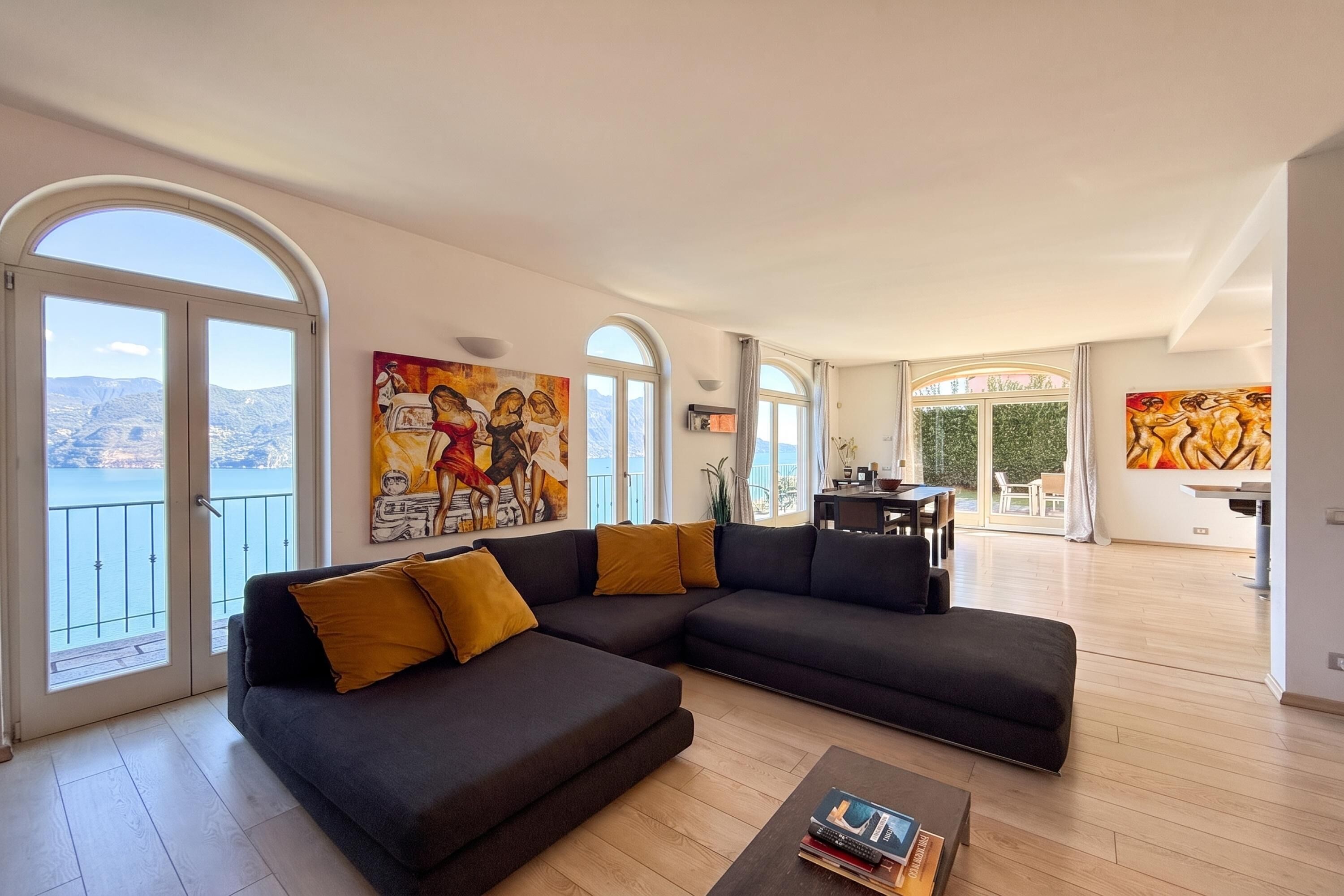 A modern living room with a sectional sofa, a coffee table, and artwork on the walls.