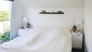 A bedroom with a bed, two nightstands, a shelf with motivational quotes, and a window with plants. - Lovely home in Storvorde with kitchen (Storvorde)