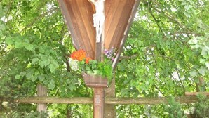 A wooden crucifix structure surrounded by lush greenery. - Private apartment in the Dolomites: 2-8 persons (St. Lorenzen)