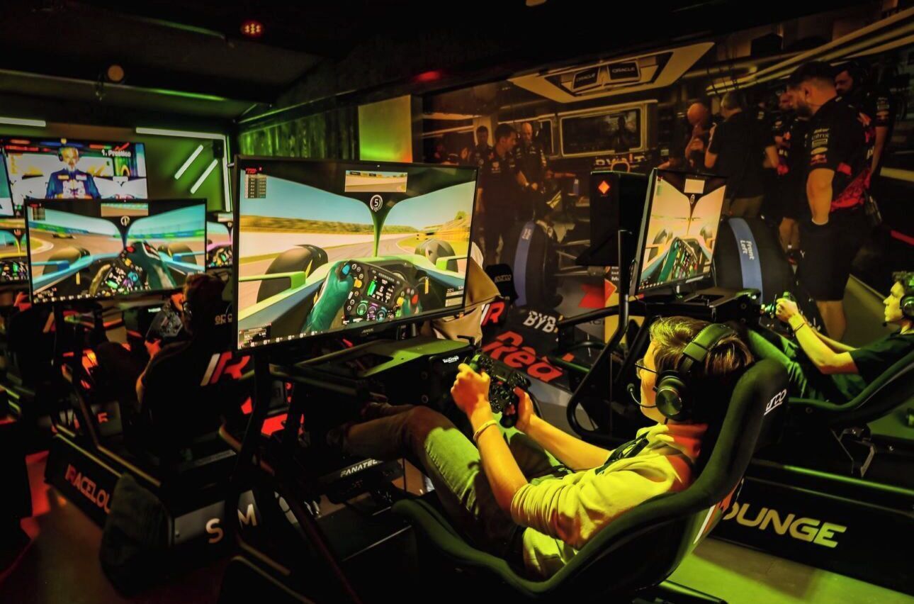 Un simulateur de course équipé de plusieurs écrans et d’un volant.