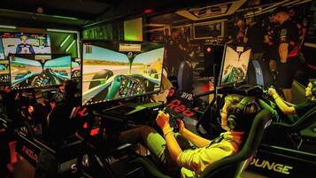 Un simulateur de course équipé de plusieurs écrans et d’un volant.