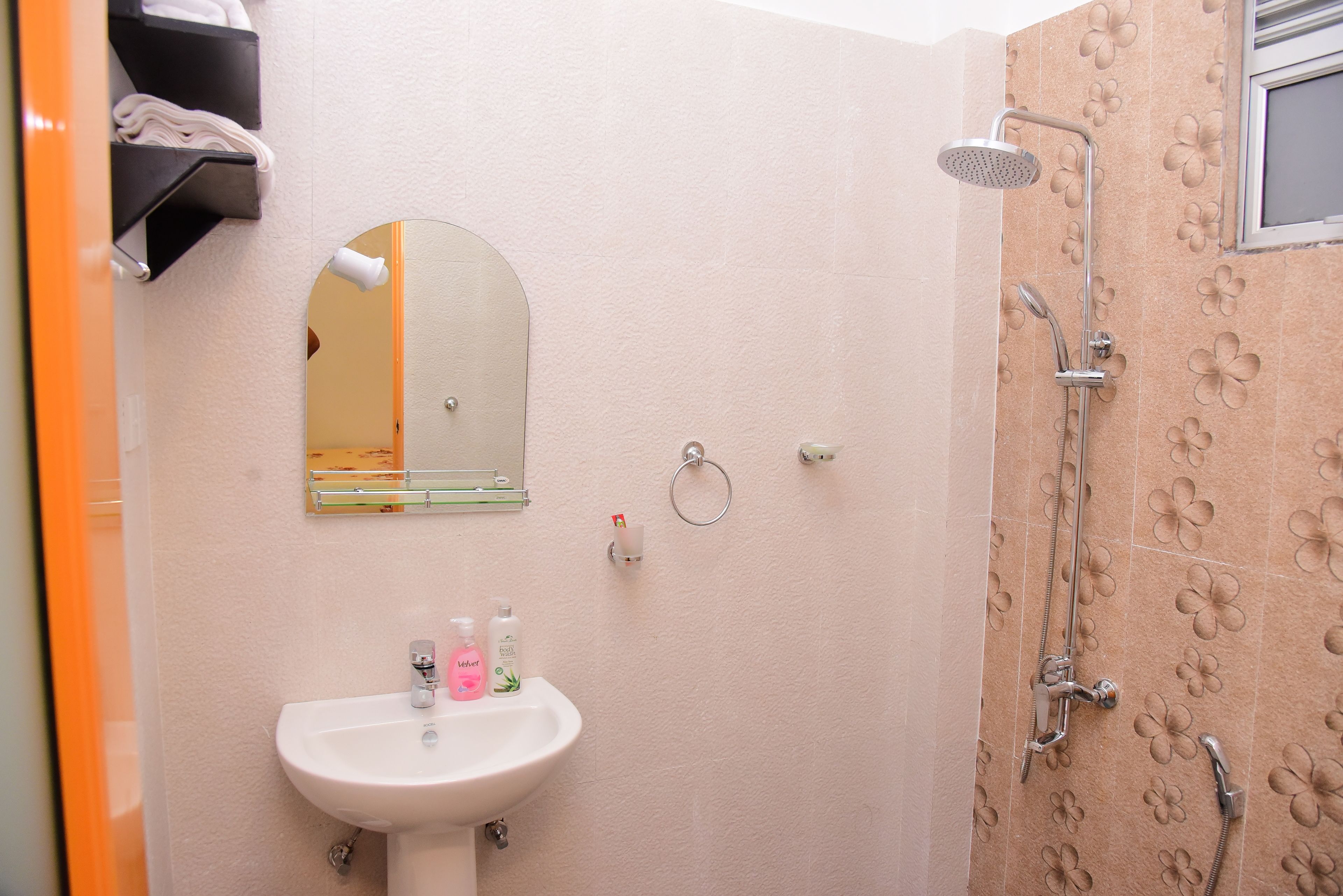 A bathroom with a sink, mirror, and shower.