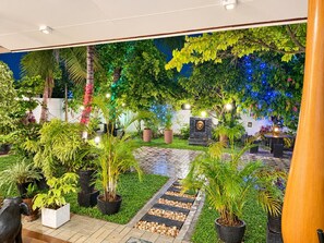 A well-maintained indoor garden with potted plants, a stone pathway, and a seating area. - White Villa Airport Transit Hotel (Seeduwa - Katunayake)