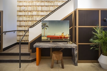 A modern living room with two rocking chairs, a coffee table, and a bookshelf. at Hotel Rendale Miami Beach