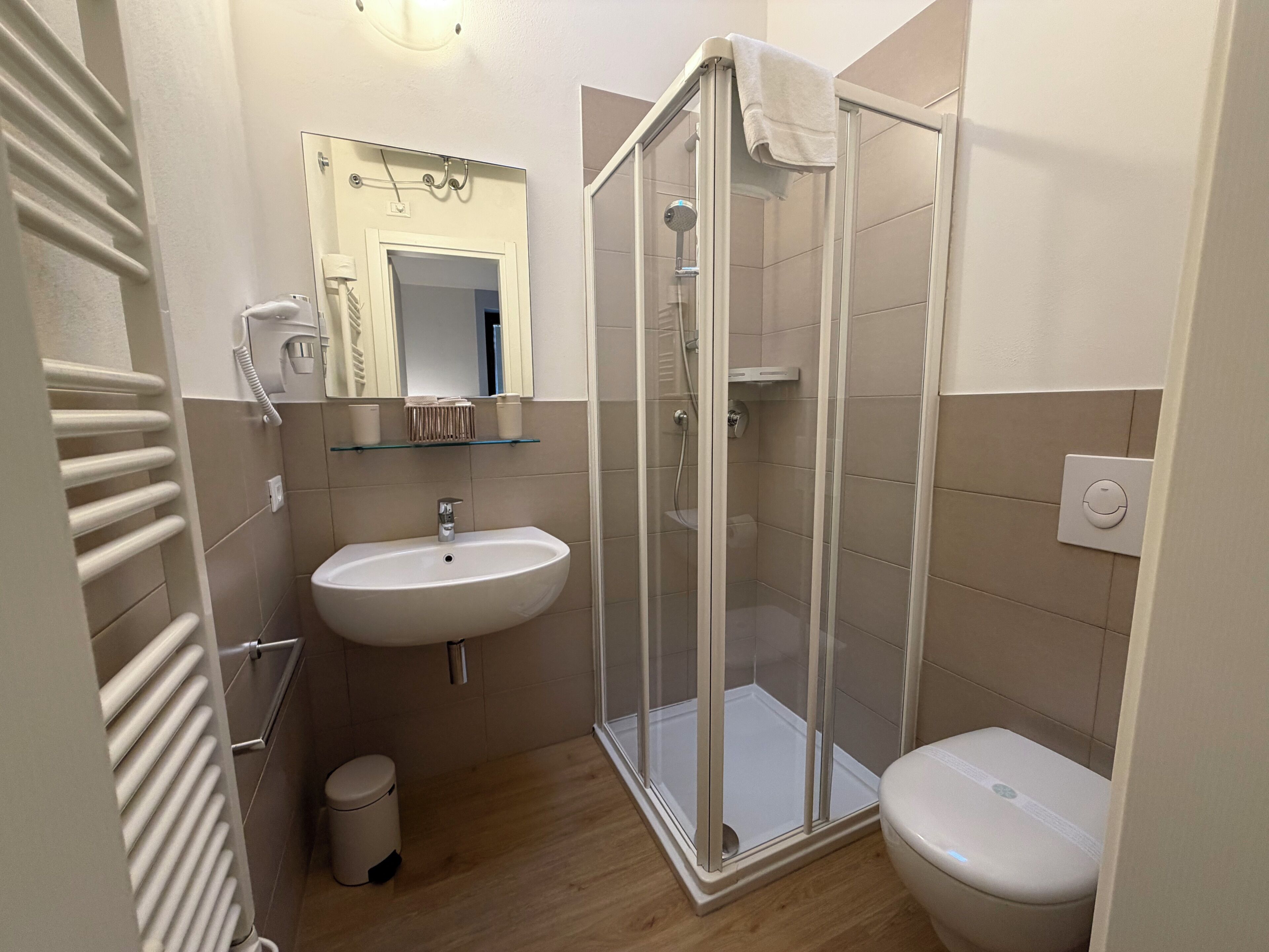 Un bagno con doccia, lavandino e WC.