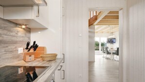 Una cocina moderna con estufa Bosch integrada, encimeras de madera y un bloque para cuchillos.
