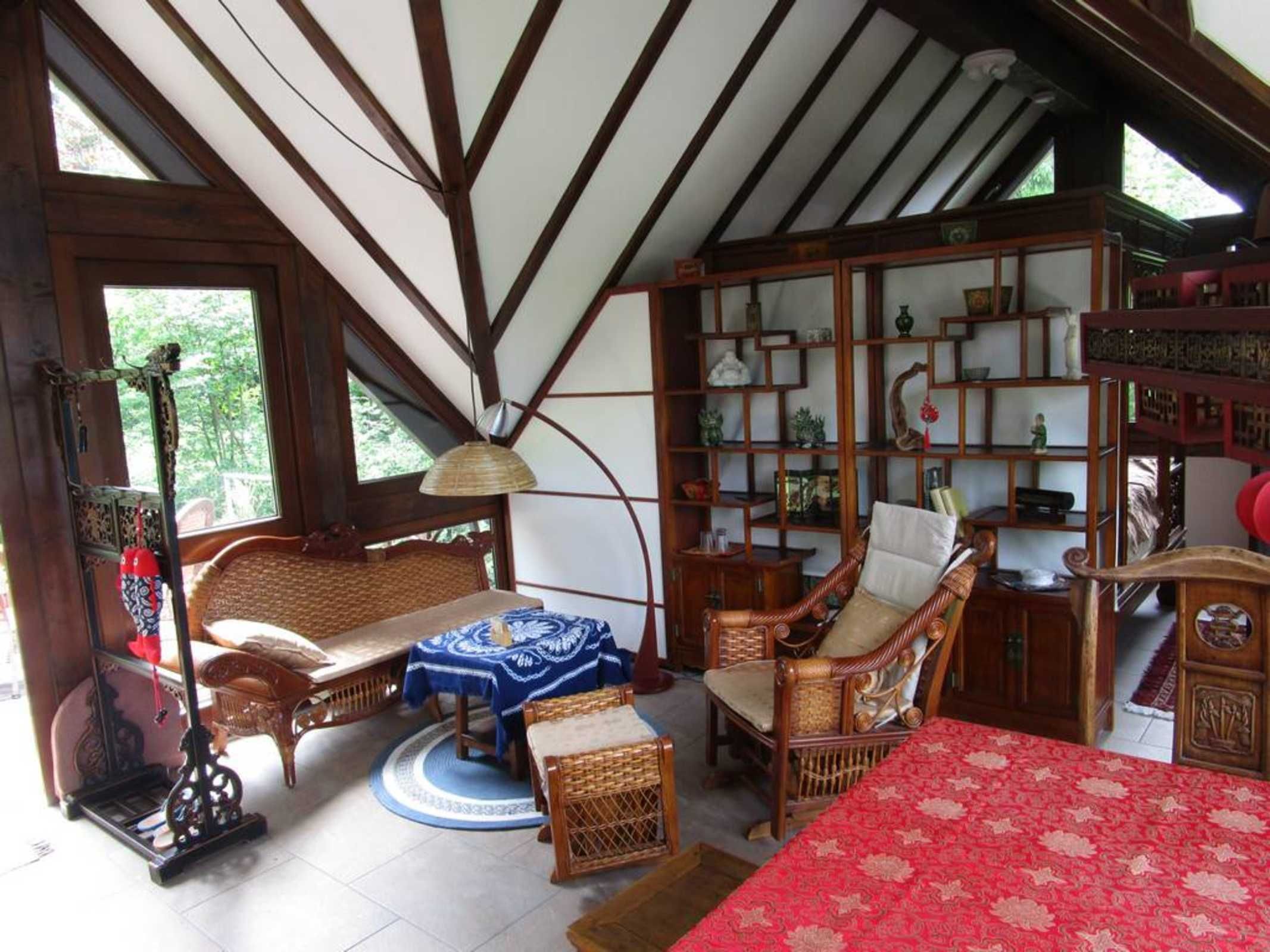 Une pièce de style traditionnel avec des poutres en bois, un canapé, un fauteuil, une table et une bibliothèque.
