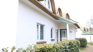 Um edifício com fachada branca, teto verde e o número '2d' na porta.