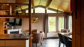 A wooden interior with a kitchen, dining area, and large windows. - La Lumière Comfort 5p (Hastière)