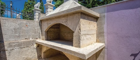 Un horno exterior de piedra con tapa plana y una única abertura arqueada.