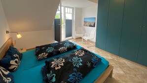 Um quarto com uma cama, uma cadeira e um guarda-roupa.