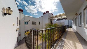 A covered outdoor area with a metal railing, potted plants, and a tiled floor. - Nice, modern apartment on the beach with sea view & terrace, free WiFi (Puerto de Mogan)