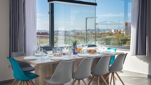 A dining table set for four with a city view, modern chairs, and a minimalist design. - Gorgeous home in Kucine (Kucine)