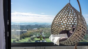 A hanging chair with a view of a cityscape and greenery. - Gorgeous home in Kucine (Kucine)