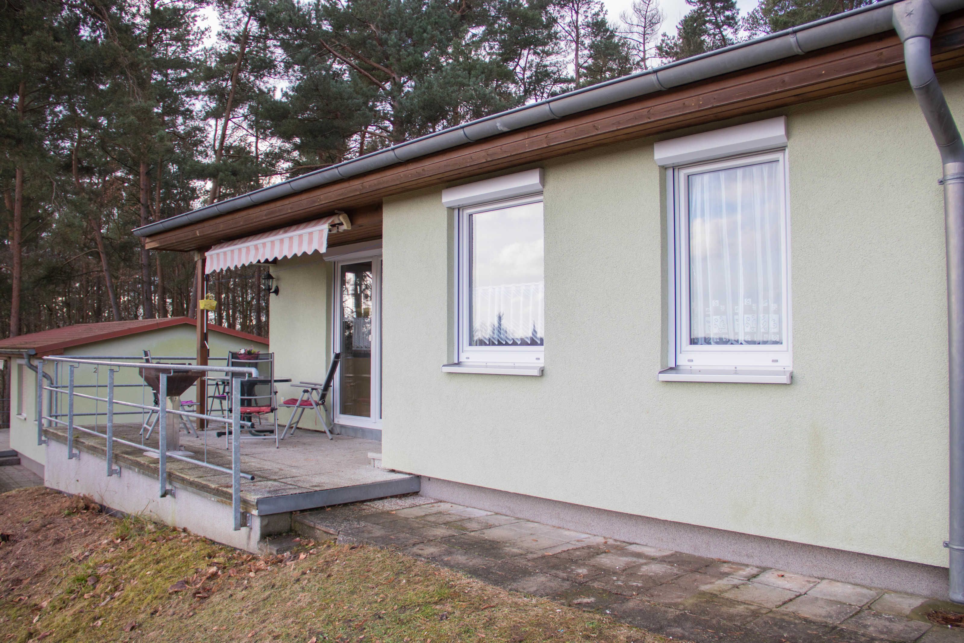 A building with a covered outdoor area, a window, and a door.