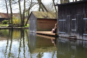 Una struttura in legno con una panchina, un piccolo molo e un tratto d'acqua.
