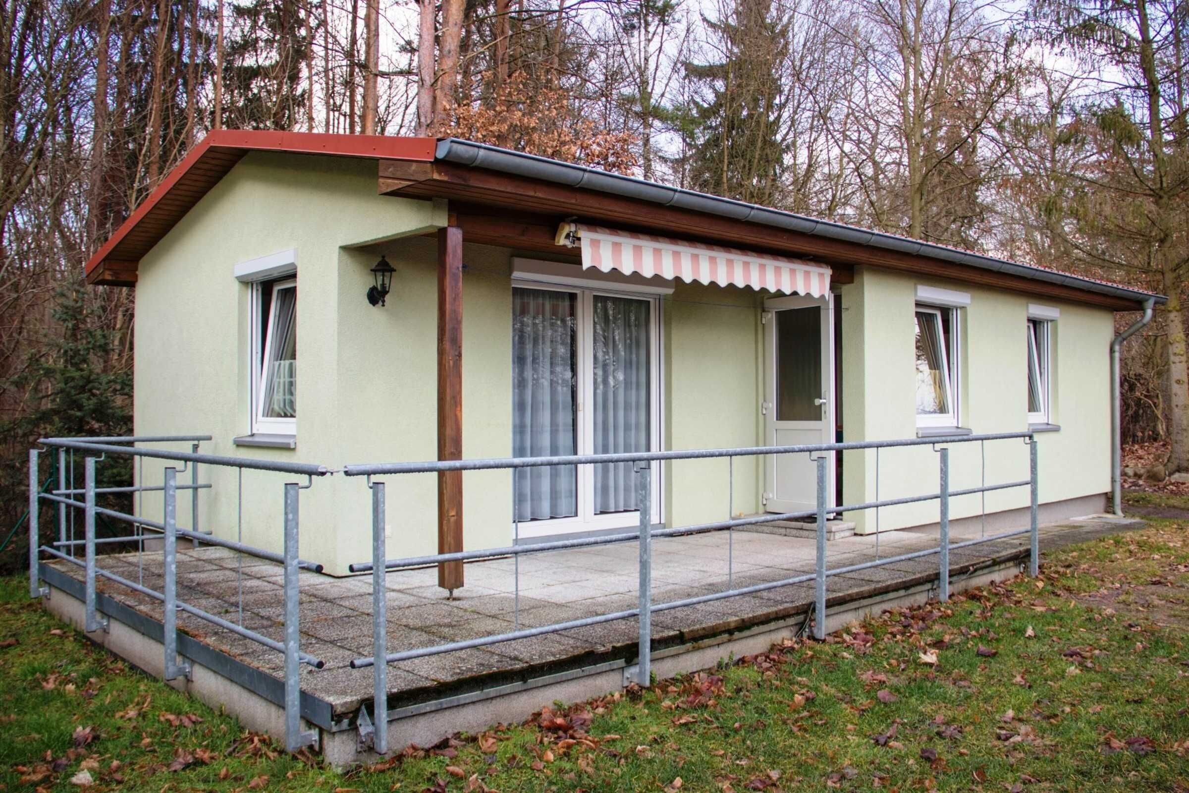 A small, single-story building with a porch, a small window, and a door.