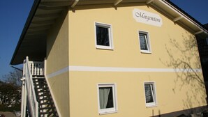 A two-story building with a yellow facade, white trim, and a sign reading "Morgenstern."