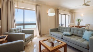 Un soggiorno con due divani, un tavolino da caffè e vista sul mare.
