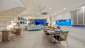 Eine moderne Küche mit blauer Arbeitsplatte, ein Essbereich mit Holztisch und Stühlen sowie eine Treppe mit einem besonderen Design.