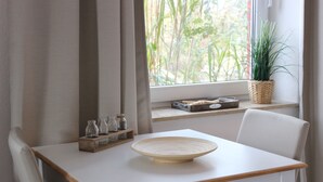 A dining table with a bowl, a potted plant, and a shelf with jars. - Vacation apartment Matrosennest - OSTSEE-Ferienwohnungen (Hasselberg)