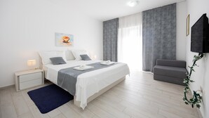 A modern bedroom with a bed, bedside table, and a small seating area. - Beautiful home in Kastel Stafilic with sauna (Kastel Stafilic)