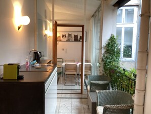 A kitchen with a sink, a mirror, and a dining area with chairs and a table. - LuxuryPenthouse in the heart of  Vienna (Leopoldstadt)