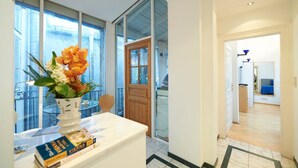 A modern hotel room with a large window, a wooden door, and a view of the outdoors. - Luxury Penthouse in the ❤️ Of Vienna (Leopoldstadt)