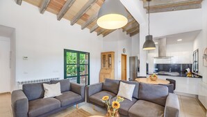 Una sala de estar moderna con dos sofás, una mesa de centro y un jarrón con flores.