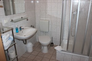 A bathroom with a sink, toilet, and shower.