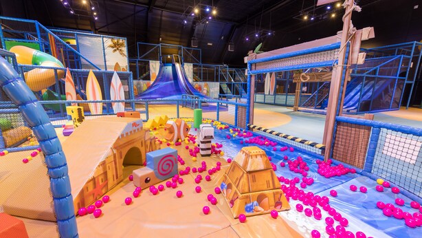 An indoor play area with slides, tunnels, and ball pits.
