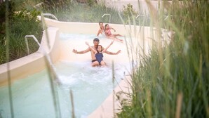 A water slide with three people sliding down.