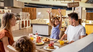 A breakfast setting with a sign indicating 'Kids Only' and a variety of breakfast items on the table.