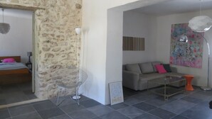 A living room with a stone wall, a sofa, a coffee table, and a chair.