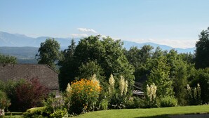 A rural landscape with a house surrounded by lush greenery and mountains in the background. - Holiday house on the outskirts of Klagenfurt with a wonderful view (Klagenfurt am Wörthersee)