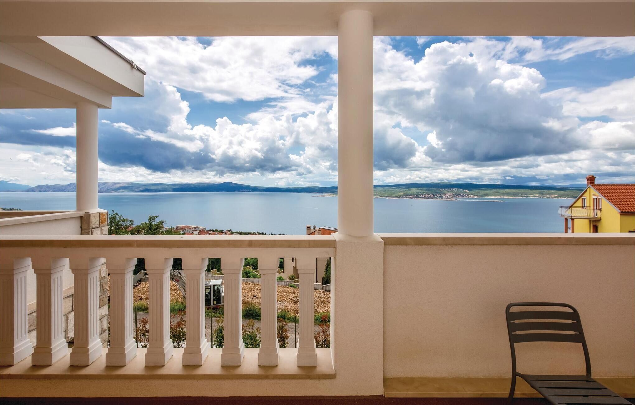 Un balcon avec vue sur un lac et des montagnes lointaines.