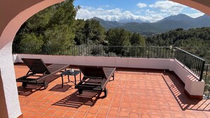 A terrace with a view of mountains, equipped with sun loungers and a table. - Casa Ensueño - an oasis of peace with fantastic views. (Jalón)