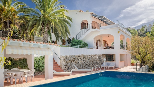 A two-story house with a swimming pool, outdoor seating, and palm trees. - Casa Ensueño - an oasis of peace with fantastic views. (Jalón)