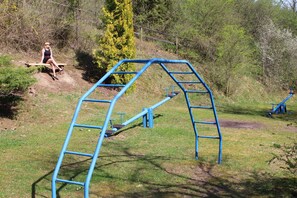 A playground with a blue climbing structure and a wooden bench. - Holiday home Charlotte - Holiday home Reinhold in Feldberg (Feldberger Seenlandschaft)