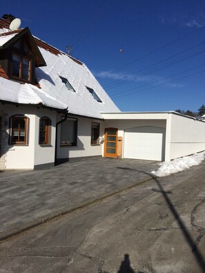 A two-story house with a snow-covered roof, a garage, and a paved driveway. - Trudis Apartment - Apartment 5 ***** (DG) (Veringenstadt)