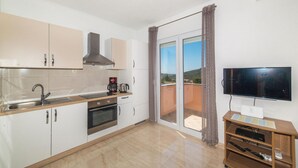 Una cocina moderna con horno empotrado, cafetera y un amplio ventanal con vistas.